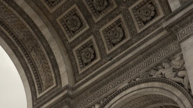 Arc de Triomphe monument interior ceiling features stone carving details in Paris France. Historic French victory inscriptions and classical relief sculpture architecture represent tourism.
