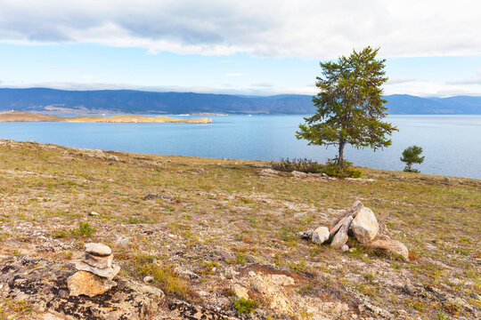Baikal Lake in summer. View of the Small Sea Strait and Ogoy Island from the steppe coast of Olkhon Island in August. Natural backdrop. Summer travel, hiking, and outdoor recreation