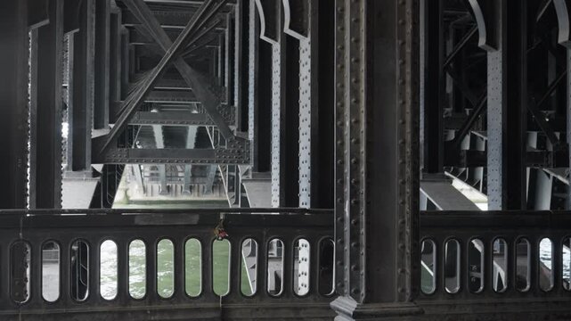 Alexandre III bridge steel support framework underneath historical landmark highlights old industrial engineering architecture with iron rivets and arched girders in Paris city infrastructure.