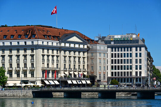 Geneva, Switzerland, Europe - 05.2026 : Luxury 5 star Four Seasons Hotel des Bergues Geneva, banners of Christie's - world's top auction house of art and luxury goods, Rolex and QNB signs background