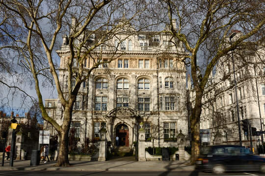 Historic office building on a London street with black cab Historic Edwardian townhouse at No.4 Hamilton Place in Mayfair London, home to the Royal Aeronautical Society, framed by leafless plane tree 