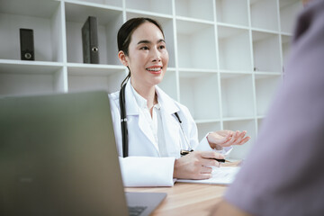 Fototapeta premium Female doctor consulting with a patient using a laptop in a modern clinic, discussing health information, treatment options, medical records, and personalized healthcare services.
