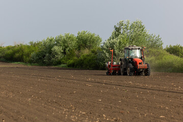 Fototapeta premium Close-up of precision planter seeding crops on cultivated farmland