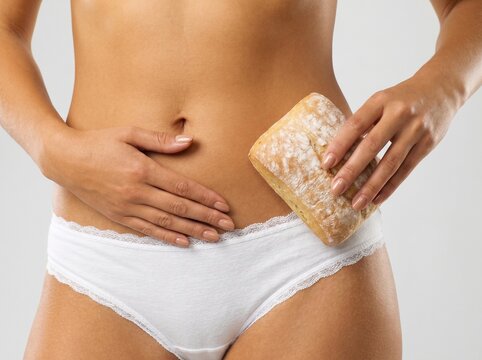 Gluten intolerance and bloating concept, woman holding bread roll against stomach, digestive health and food allergy awareness