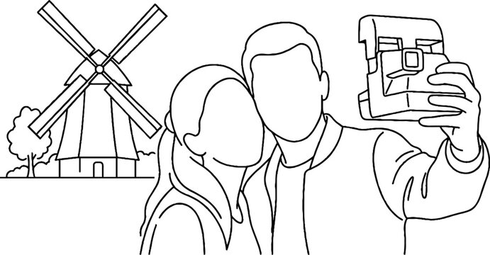 Couple taking selfie with windmill in background.