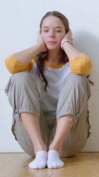 Vertical video: Straightening after start, woman in yellow top calming on floor, pink band visible