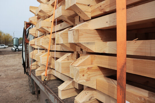 Wooden pallets are loaded onto machine. Manufacture and delivery of natural wood products. Transportation of finished products by truck