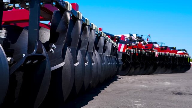 Red tractor with black cultivator tines.
