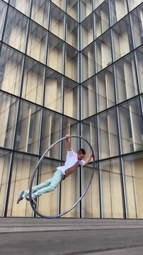 Dynamic and vibrant performance of a Cyr Wheel within urban architecture. Concept of individuality, creativity and self-confidence