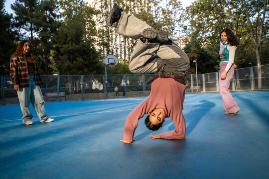 Gen-Z female urban dancers practicing breakdance outdoors