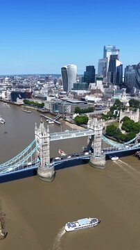 Aerial view of the iconic Tower Bridge in front of the skyline of London, England, during a sunny summer day