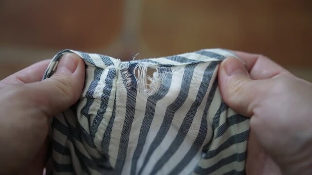 Details of old torn pants from frequent wear, damaged pants with a hole in the fabric suitable for repair and stitching