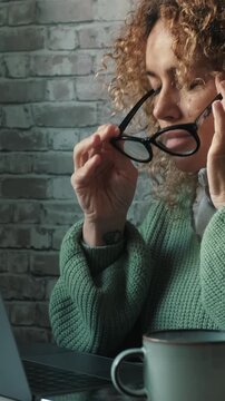 One adult woman touching her head for headache migraine after work on computer at the table. Concept of tired and stress people with problems and painful health bad condition working on laptop online