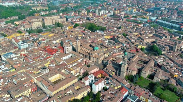 Aerial drone view of Parma's historic center featuring Parma Cathedral, octagonal Baptistery, and Palazzo della Pilotta in Emilia-Romagna, Italy, daytime.