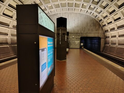 Washington, DC, USA - March 3, 2025: An empty underground Federal Center SW station on the Washington Metro. A lightbox with a bright advertisement in English and Spanish glows on the side panel.