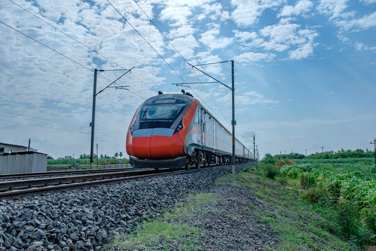 Saffron coloured Vande Bharat Express near Pune India. This is a made in India train set and also known as Train 18.
