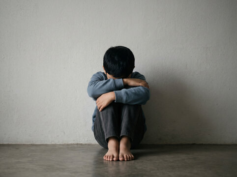 anonymous child sitting alone representing childhood trauma emotional distress and mental health awareness concept