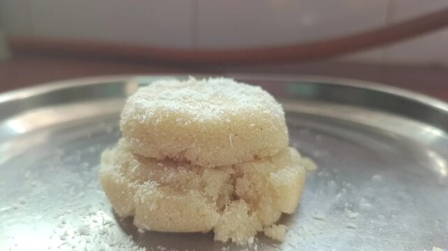 Garnishing Homemade Suji Halwa Sandesh Mithai With Coconut Flakes On Stainless Steel Plate