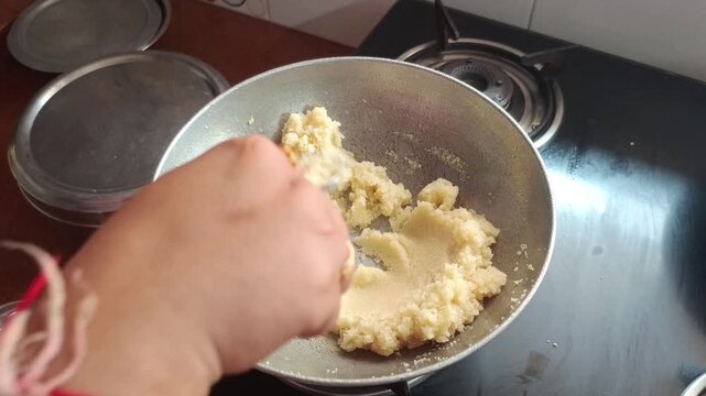 Stirring And Preparing Homemade Suji Halwa Or Mithai In Kitchen