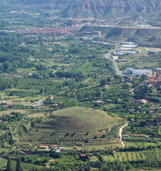 Fototapeta premium Town and Green Valley Below Eroded Hills in La Rioja