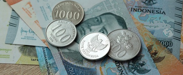 Indonesian rupiah money bills and coins on table. Indonesia cash of IDR currency © Larysa