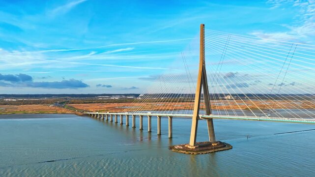 Cable-stayed structure of Normandy Bridge over calm estuary water, aerial footage of a well-known French river crossing