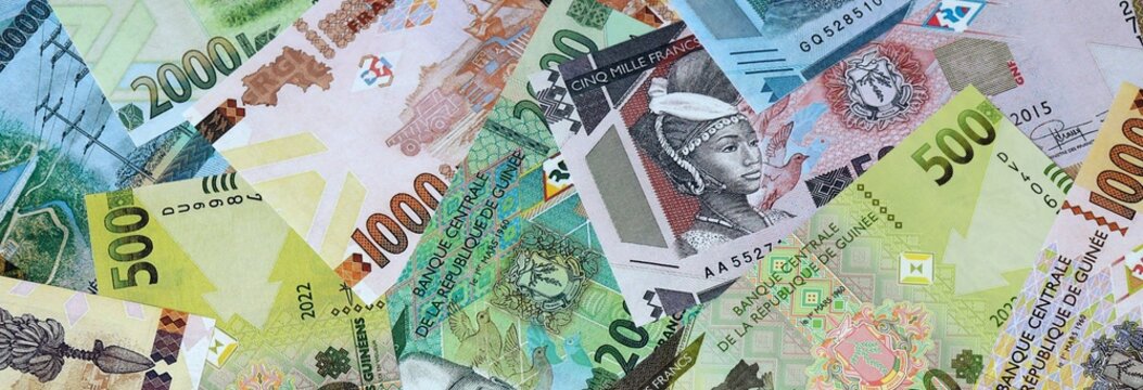 Guinean franc money banknotes bunch on table. Guinea bills of GNF currency close up