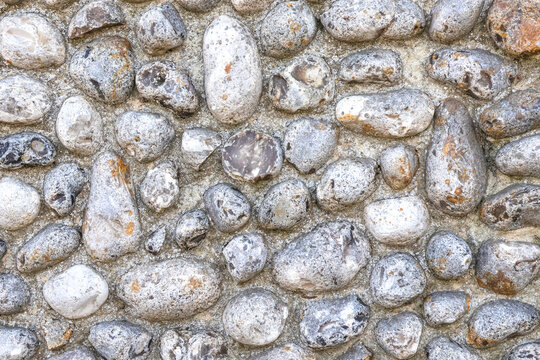 A Norfolk flint wall made of round stones in closeup