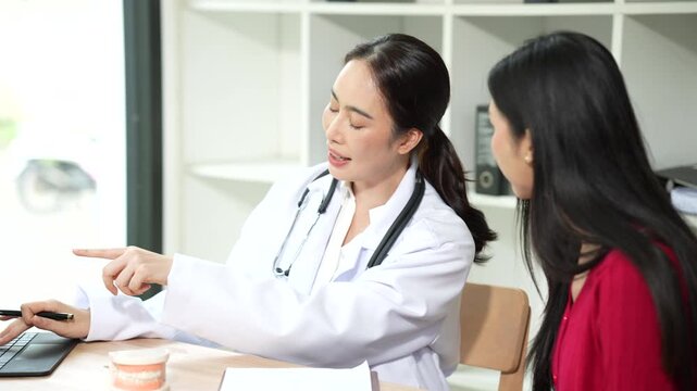 Professional dentist consulting with a patient in a modern dental clinic, explaining teeth restoration, prosthetic options, oral health care, treatment plans, and dental hygiene during a routine check