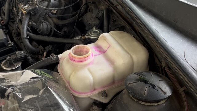 Coolant reservoir tank in a car engine bay
