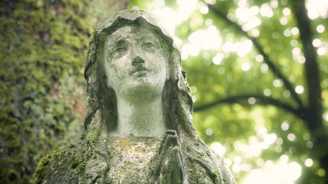 Weathered St. Mary statue in the rain at Bernardine Cemetery, Vilnius, Lithuania