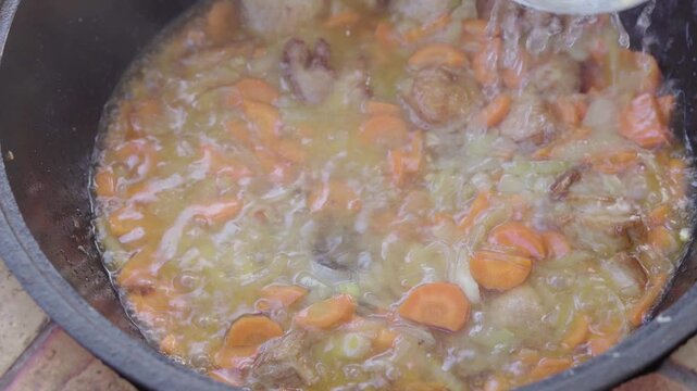 Pouring Water into Cauldron to Cook Zirvak for Plov
