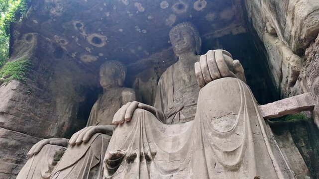 Dazu, China : Tilt down footage of two Buddhas Seated side by side, giant carvings part of Beishan grottoes in Dazu rock carvings, famous cave rock art in Chongqing, China