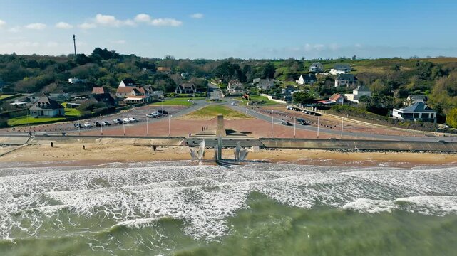 Omaha Beach in Normandy, France, with Les Braves memorial, shoreline and waves. Aerial drone view of historic D-Day landing beach