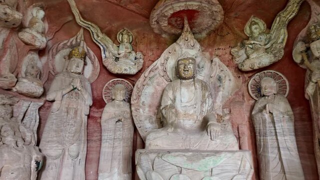 Dazu, China : Tilt down footage of Buddha statue, part of Beishan grottoes in Dazu rock carvings, famous cave rock art complex thtat dates from the 9th century near Chongqing in China