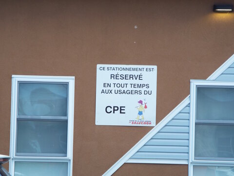 Gatineau,Quebec, Canada &ndash; May 15, 2026: A sign on a brown building wall states that parking is reserved at all times for "CPE" users on Rue B&eacute;dard.