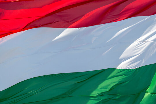 Hungarian flag waving in bright sunlight with vivid colors in a clear outdoor setting during the day