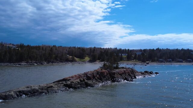 High-resolution drone capture of an iconic St. Lawrence River islet with evergreen trees, rocks, and breathtaking Canadian coastal views.