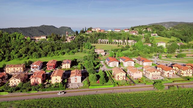 Aerial view of residential houses in Costermano sul Garda surrounded by vineyard fields and rural landscape, northern Italy