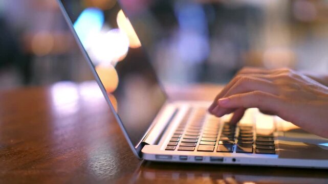 Close up of hands typing on laptop keyboard, professional person working on notebook computer in cafe, remote work and digital nomad lifestyle