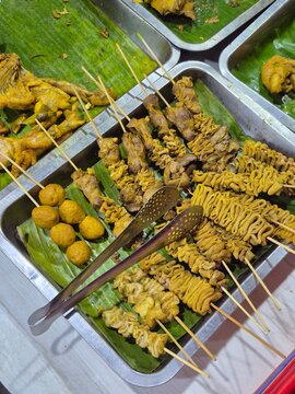 Indonesian street food menu featuring sate usus (intestines), sate ati ampela (gizzard and liver), and meatball skewers
