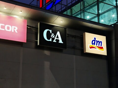 Prague,Czech Republic-April 2 2026: C&A and DM retail store logos illuminated on a shopping center facade at night