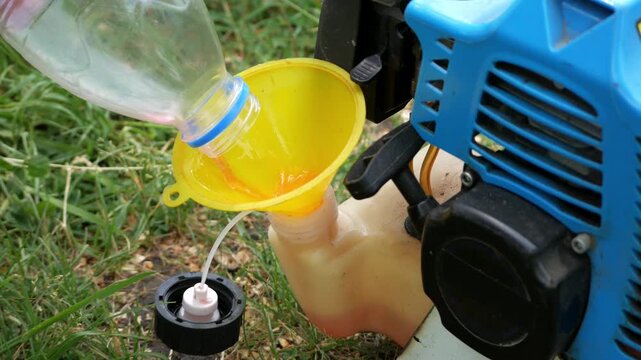 Close Up of Refueling a Gasoline String Trimmer Before Grass Cutting