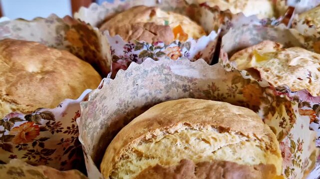 Close-up view of freshly baked sweet yeast breads in colorful floral paper liners. Concept of traditional Easter baking, homemade treats, and festive holiday breakfast pastries.