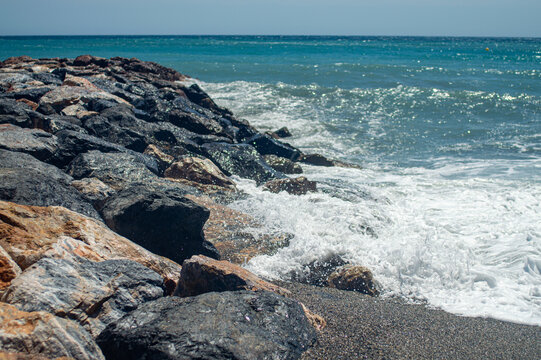 Stormy Mediterranean Sea with deep blue waves crashing on the sunny beach in Almunecar, Andalusia, Spain.