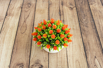 Obraz premium Small table decoration featuring a bright green plastic succulent in a mini white ceramic pot that mimics terracotta