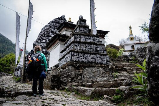 Mujer mirando estupas y rezos budistas tallados en piedra, en la regi&oacute;n del valle de khumbu. Camino al Everest Base Camp.