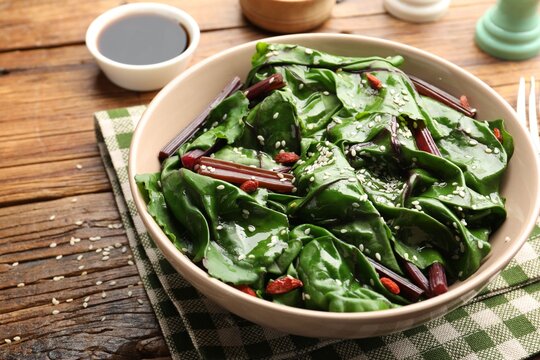 Salad with beetroot leaves served on wooden table, closeup