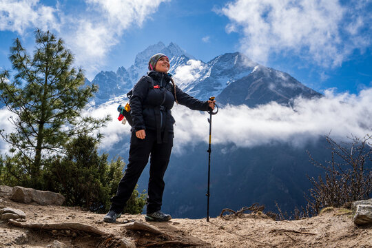 Mujer feliz caminando por los espectaculares caminos del valle khumbu. Yendo al Everest Base Camp, en Nepal.