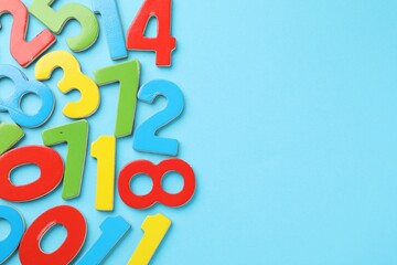 Fototapeta premium Colorful numbers on light blue background, flat lay. Space for text